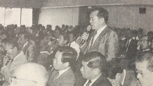 シンポジウムで発言する男性